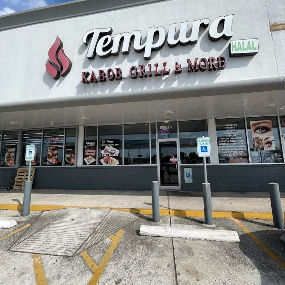 Exterior of Tempura Halal Indo-Pak Grill, a restaurant with a gray facade and large windows.