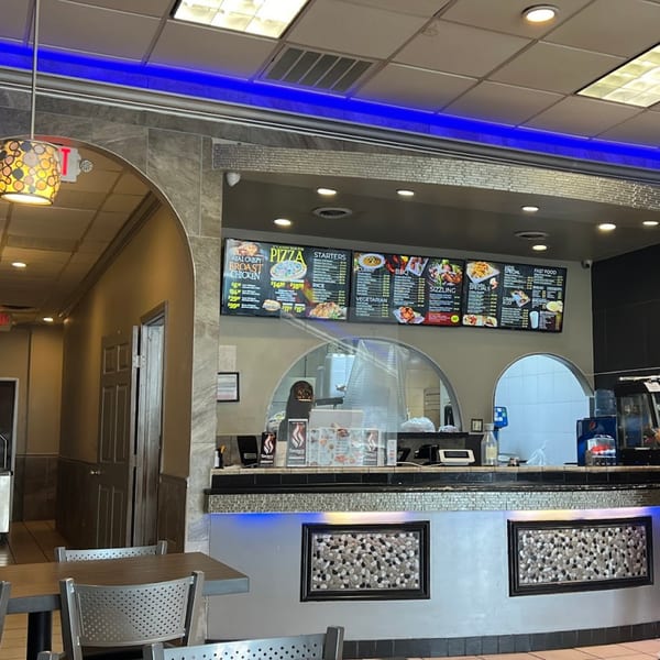 Interior of Tempura Halal Indo-Pak Grill, showing the counter with menu boards and dining area.