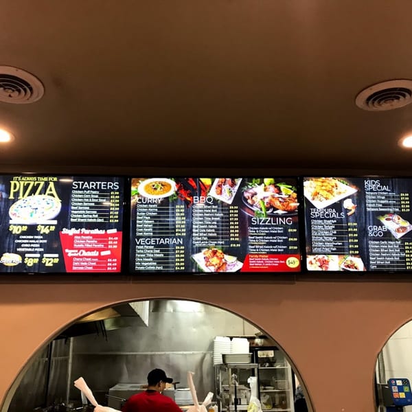 Digital menu boards display Pakistani cuisine categories like Curry, BBQ, Sizzling, and Tempura Specials.