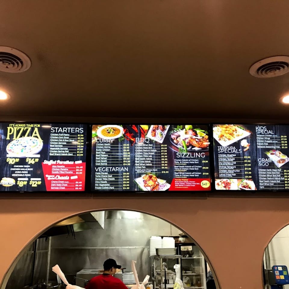 Digital menu boards display Pakistani cuisine categories like Curry, BBQ, Sizzling, and Tempura Specials.